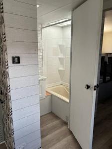 Baño blanco con bañera y lavamanos en Feel the Vibe en Pensacola