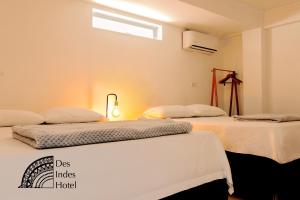 duas camas sentadas uma ao lado da outra num quarto em DES INDES CARTAGENA em Cartagena das Índias
