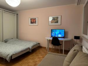 1 dormitorio con cama y escritorio con ordenador. en Cozy Flat in the Center of Kleinbasel, en Basilea