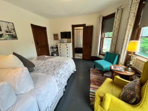 a bedroom with two beds and a chair at iKlektik House / Bagley in Detroit