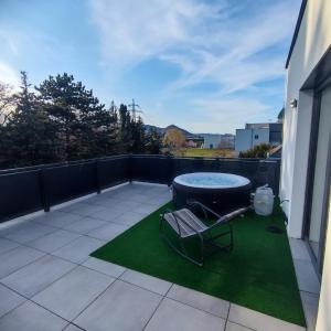 un patio con bañera de hidromasaje y silla en Aparthotel Umbrella en Viena