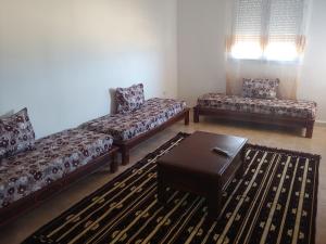 a living room with two couches and a coffee table at Appartement F3 Fil-Fila Skikda in Skikda