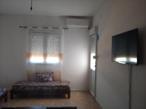 a living room with a couch and a flat screen tv at Appartement F3 Fil-Fila Skikda in Skikda