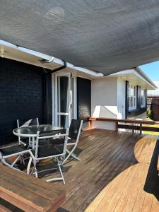 patio con tavolo e sedie su una terrazza di Hilltop Cottage a Taupo