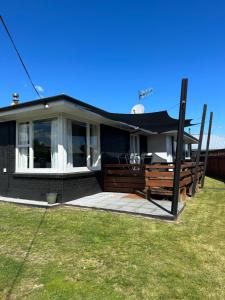 a house with a porch with a black roof at Hilltop Cottage in Taupo