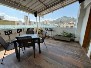 卡利的住宿－HOTEL SAN ANTONIO PLAZA，带阳台的带桌椅的房间