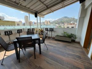 a room with a table and chairs on a balcony at HOTEL SAN ANTONIO PLAZA in Cali
