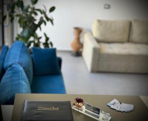 sala de estar con sofá azul y mesa en Mucobega Hotel, en Sarandë