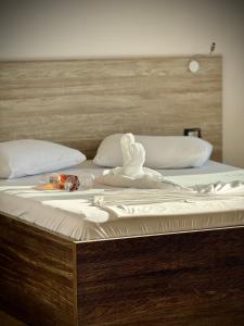 Una cama con una toalla encima. en Mucobega Hotel, en Sarandë