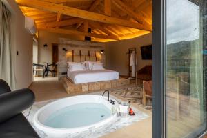 a master bedroom with a tub and a bed at Dajas Douro Valley - Exclusive Villas in Sande