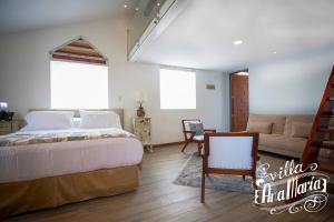 une chambre avec un grand lit et un canapé dans l'établissement Villa Ana María Cuenca-Hotel, à Chaullamba