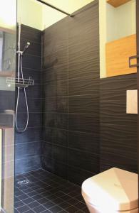 a bathroom with a toilet and a shower with black tiles at Sunny - Studio confortable près de la Tour Eiffel in Paris