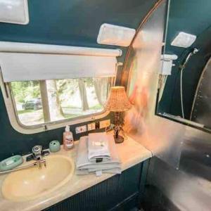 a bathroom with a sink and a mirror at Airstream at a Petting Zoo w/ Hot Tub in Sugar Grove