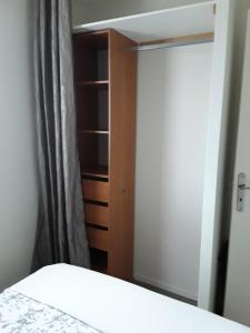 Appartement à 100 mètres de la plage في اويسترهام: غرفة نوم مع خزانة وسرير أبيض