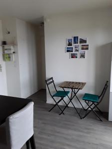 - une chambre avec deux chaises et une table dans l'établissement Appartement à 100 mètres de la plage, à Ouistreham