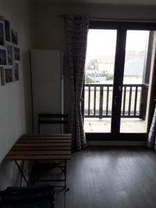 Appartement à 100 mètres de la plage في اويسترهام: غرفة مع طاولة وباب زجاجي منزلق