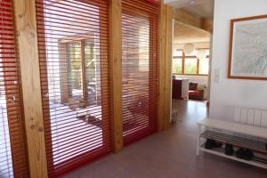 Habitación con persianas de madera en las puertas correderas de cristal. en Chalet avec grand jardin en Chartreuse Alpes, en Miribel-les-Échelles