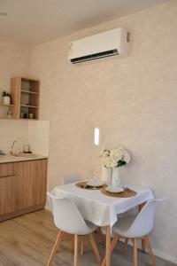 uma cozinha com uma mesa com um vaso de flores em Домик 1 Kok Tobe Village em Almaty