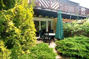 波東耶的住宿－Domek Leśny，一个带桌子和遮阳伞的庭院