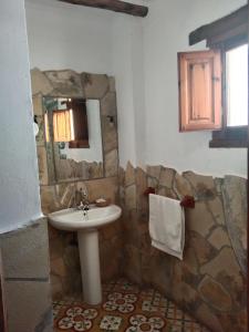 ein Bad mit einem Waschbecken und einem Spiegel in der Unterkunft La Posada del Altozano in Lanteira