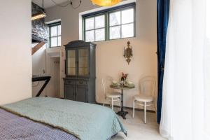 een slaapkamer met een bed en een tafel met stoelen bij De Loods in Kampen