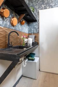 een keuken met een wastafel en een witte koelkast bij De Loods in Kampen