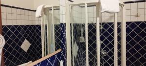 a bathroom with a shower with blue and white tiles at Hotel Colosseo Colleferro in Colleferro +78 photos