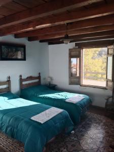 1 dormitorio con 2 camas y ventana en La Posada del Altozano, en Lanteira