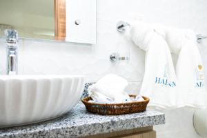 - Baño con lavabo y cesta de toallas en Habana Hotel Y Restaurante, en Higüey
