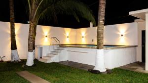 a swimming pool at night with palm trees at Villa Tataya Nawi in Monte Gordo