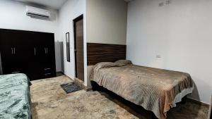 a bedroom with a bed and a black cabinet at Villa Tataya Nawi in Monte Gordo