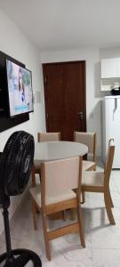 a dining room with a table and chairs and a tv at Apartamento Recreio p12 in Rio de Janeiro