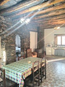 comedor con mesa y pared de piedra en La Posada del Altozano, en Lanteira