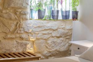 una camera con un muro in pietra con piante in vaso su una finestra di Le Sirene B&B a Ragusa