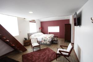 1 dormitorio con 1 cama y sillas en una habitación en Ana María Hospedaje en Chaullamba