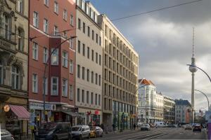 a busy city street with buildings and cars on the road at Apartment at Rosenthaler Platz in Berlin