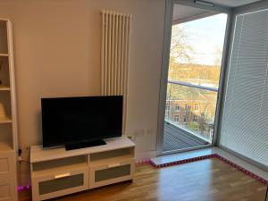 a living room with a flat screen tv and a large window at LUXURY Leicester apartment in Leicester