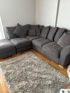 a grey couch in a living room with a rug at LUXURY Leicester apartment in Leicester