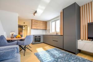 a kitchen with a table and blue chairs in a room at House Sea Stone in Dobropoljana