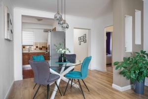 a dining room with a glass table and blue chairs at Apartment DaNka in Vodice
