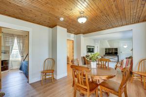 uma sala de jantar e sala de estar com tecto em madeira em Charming Muskegon Cottage - Walk to Lake Michigan! em Muskegon