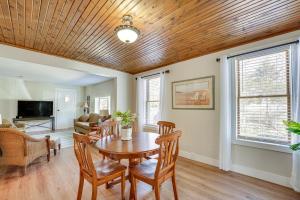 uma sala de estar com um tecto de madeira e uma mesa e cadeiras em Charming Muskegon Cottage - Walk to Lake Michigan! em Muskegon