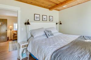 ein Schlafzimmer mit einem großen Bett und einer Holzdecke in der Unterkunft Charming Muskegon Cottage - Walk to Lake Michigan! in Muskegon
