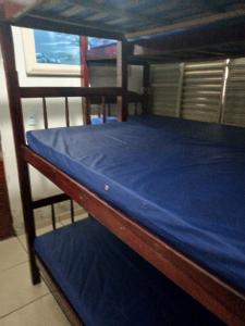 a wooden bunk bed with a blue sheet on it at Espaço com piscina in Sorocaba