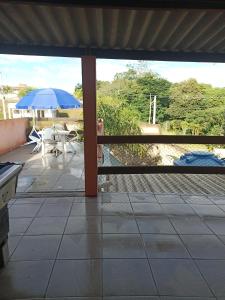 a patio with a table and an umbrella at Espaço com piscina in Sorocaba