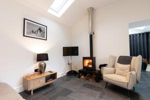 sala de estar con silla y chimenea en The Bothy, en Ulverston