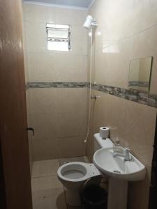 uma casa de banho com um WC branco e um lavatório. em Espaço com piscina em Sorocaba