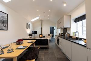 cocina y sala de estar con mesa y sofá en The Bothy, en Ulverston