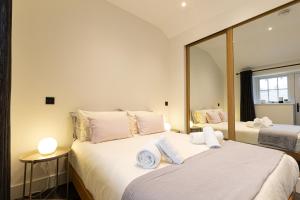 1 dormitorio con 2 camas y un espejo grande en The Bothy, en Ulverston