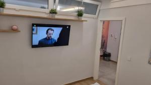 a television on a wall in a living room at Apartament BRYZA in Pobierowo